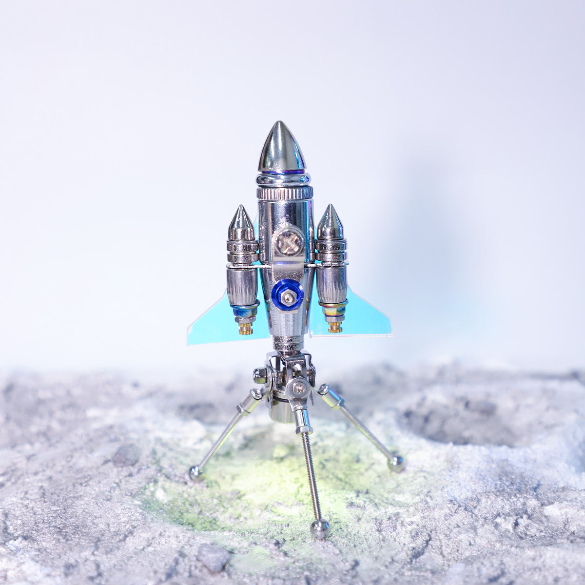 Model rocket on a stand with a light blue background