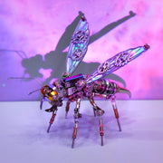 Metal insect sculpture with iridescent wings on a white surface with a purple gradient background
