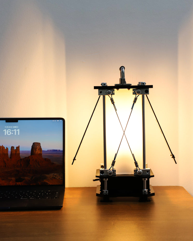 Laptop on a desk with a 3D printer in the background