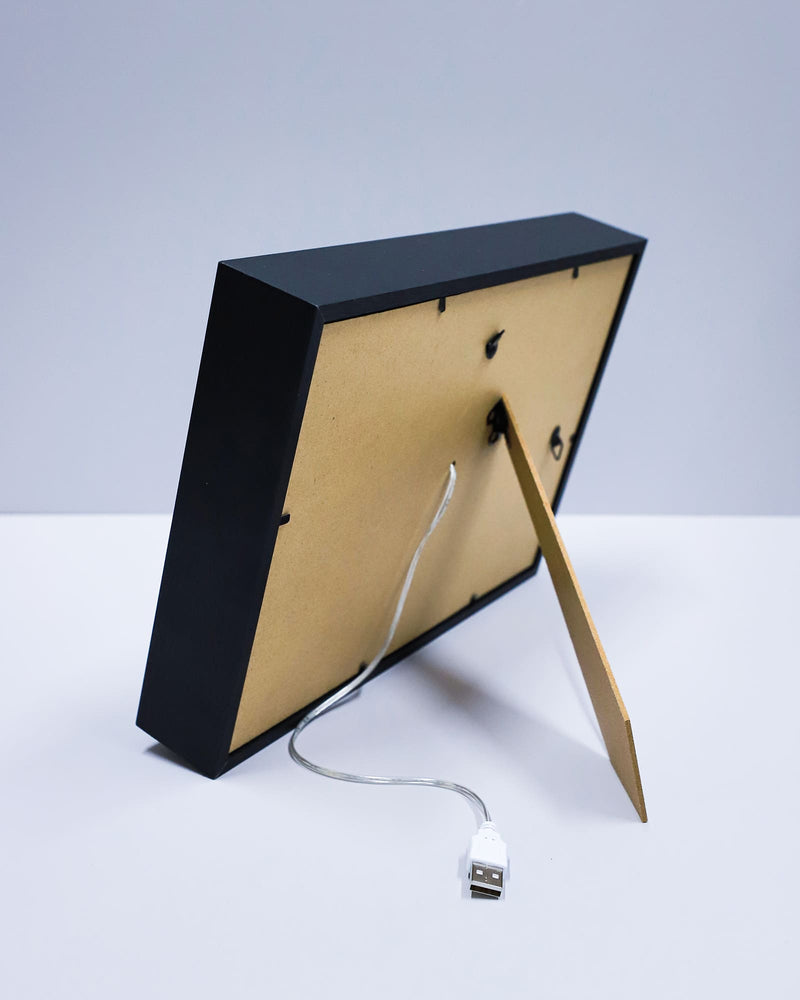 Black and gold electronic device with USB cable on a white background