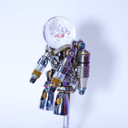 Metallic robot figure with a clear glass ball on a white background