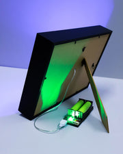 Black rectangular device with green light on a white surface