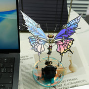 Decorative butterfly with mechanical elements on a magazine next to a laptop