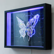 Futuristic butterfly design with gears inside a black frame on a white wall
