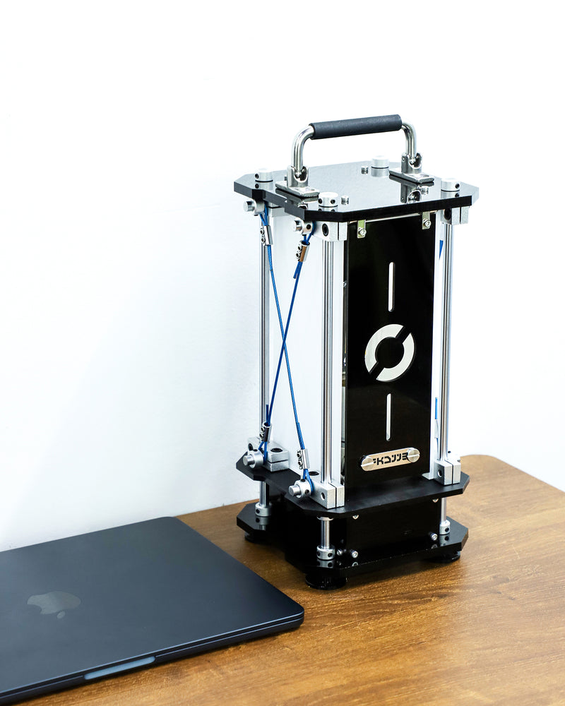 3D printer on a wooden table with a laptop