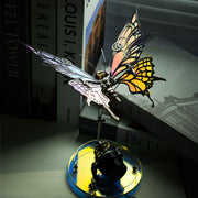 Decorative butterfly sculpture on a reflective base with books in the background