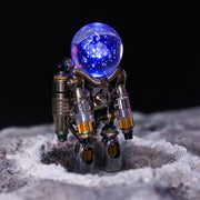 Metallic robot figure with a glowing blue sphere on a textured surface