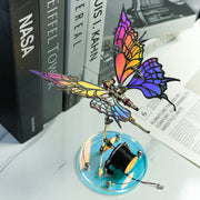Colorful butterfly sculpture on a stand with books in the background