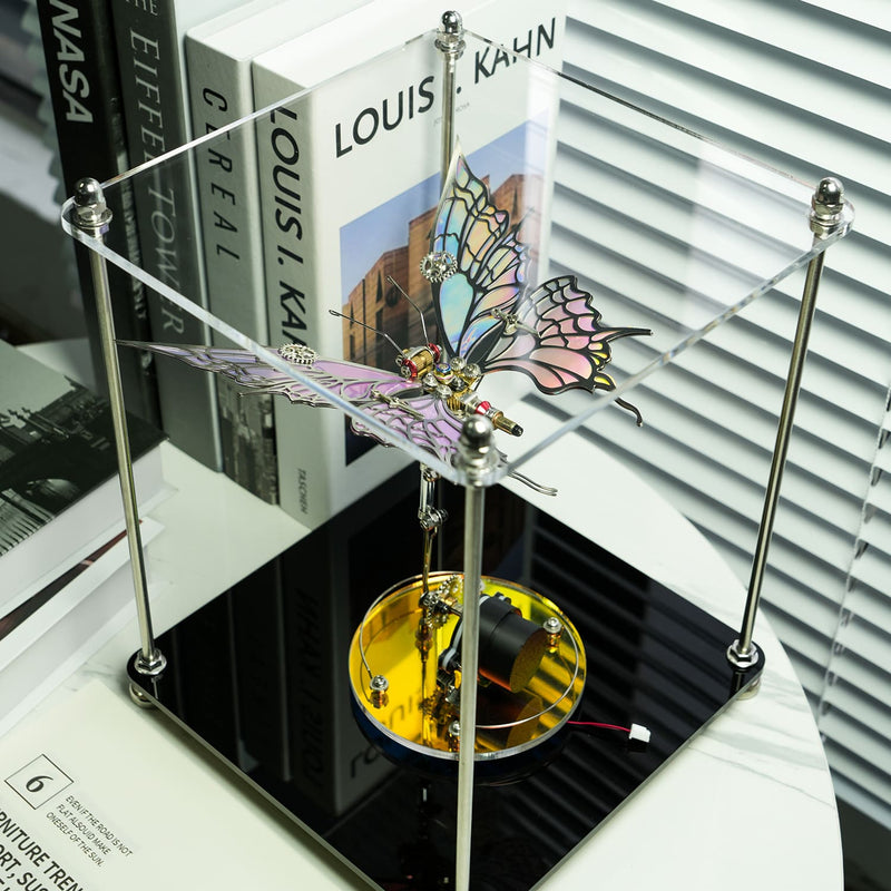 Butterfly-shaped mechanical device on a stand with books in the background