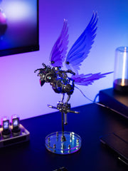 Mechanical bird sculpture with wings on a stand against a blurred background