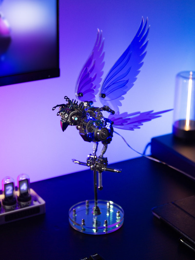 Mechanical bird sculpture with wings on a stand against a blurred background
