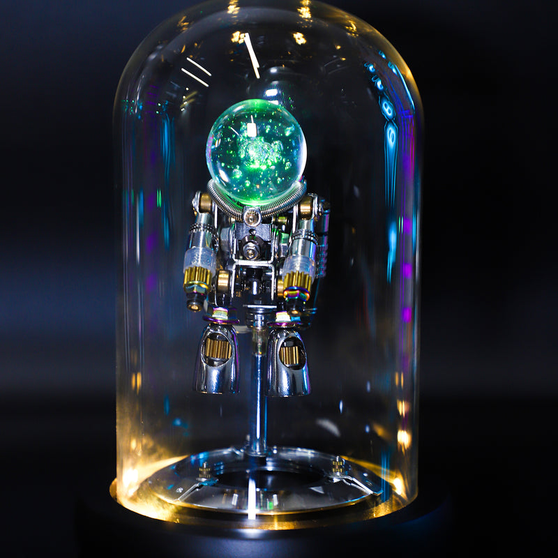 Model of an astronaut inside a glass dome with a glowing green sphere above, on a dark background.
