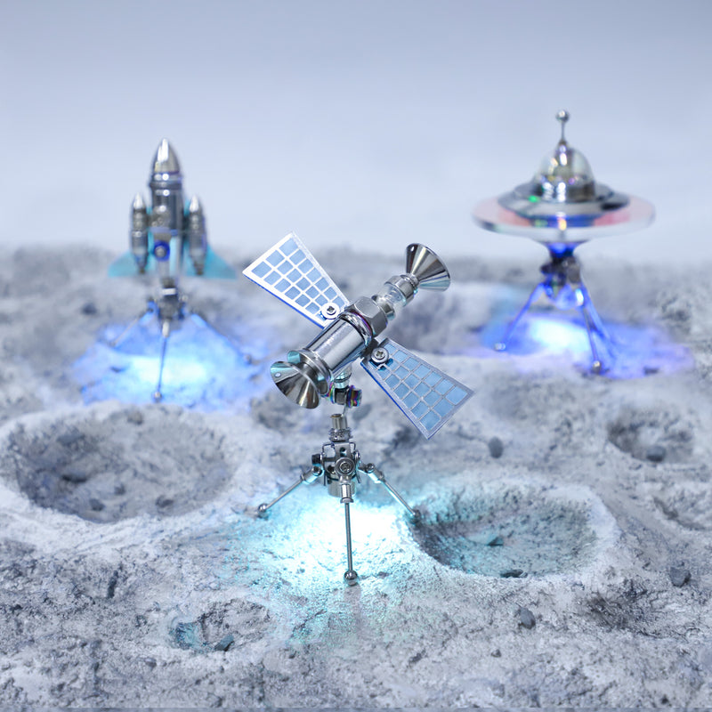 Model of a spacecraft on a lunar surface with a space station and UFO in the background.