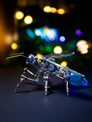 A model of a mechanical ant with color-shifting wings and glowing energy points, placed on a simulated natural terrain.