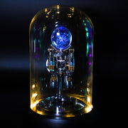 Decorative object with a blue light inside a glass dome on a dark background