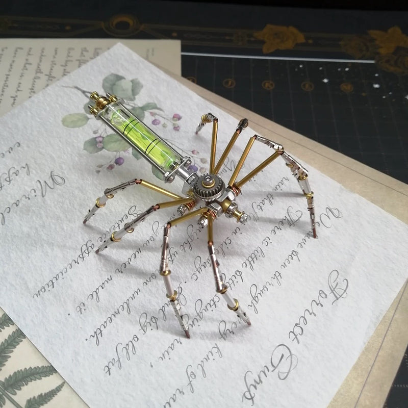 Metallic spider-like object on a piece of paper with cursive writing
