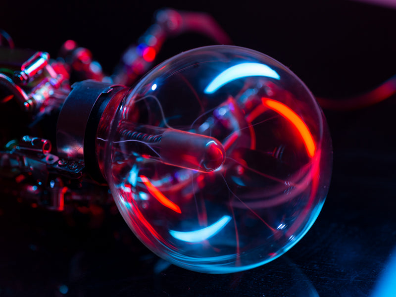 Close-up of a glowing light bulb with colorful lighting effects on a dark background
